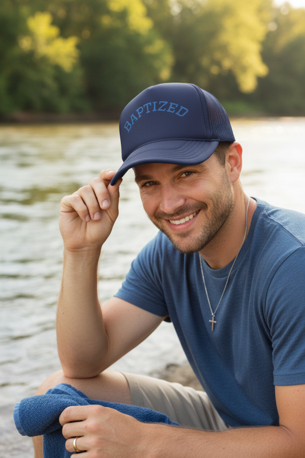 A navy blue trucker-style cap with 'BAPTIZED' embroidered in light blue arched letters on the front, shown against a plain white background.