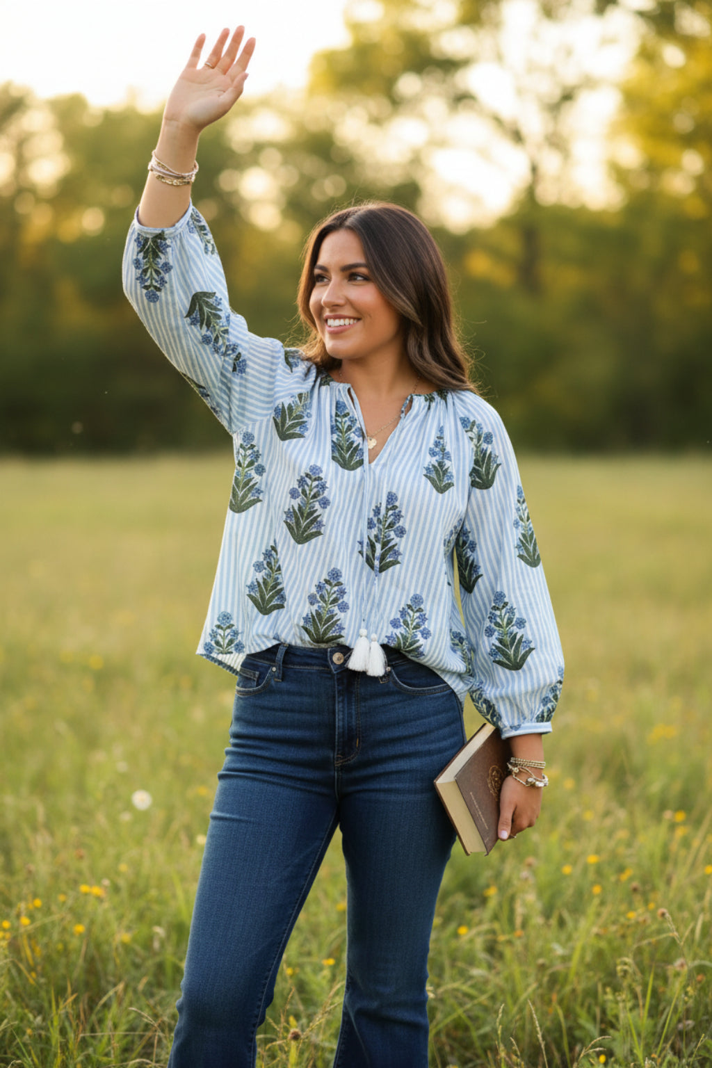 Woman wearing a floral and striped blouse with a blurred background