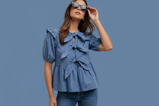 Woman wearing a blue ruffled blouse and blue jeans with blue background
