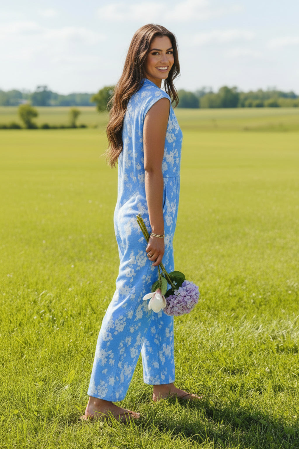 Woman wearing a blue floral romper standing outdoors 